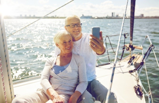 older couple taking a selfie on a boat