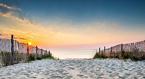 Sun rises over sand dunes on beach