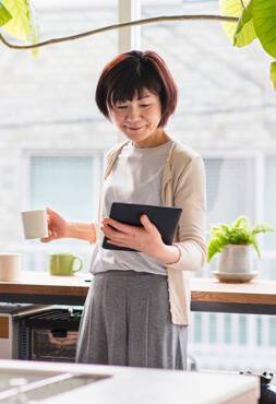 Older woman with coffee and tablet