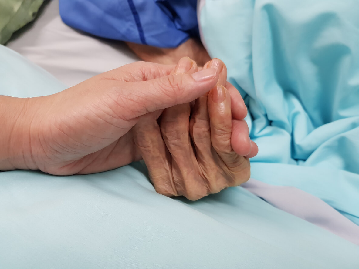 elder woman holding hands in end of life care