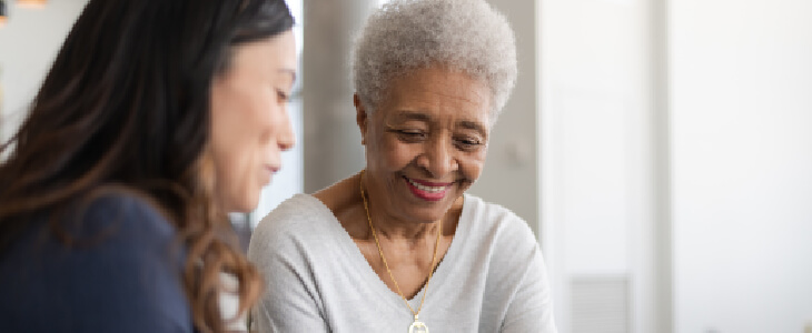 older woman smiling while talking to a younger woman masshealth