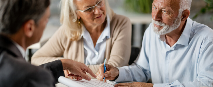 Elderly couple working on estate plan with attorney