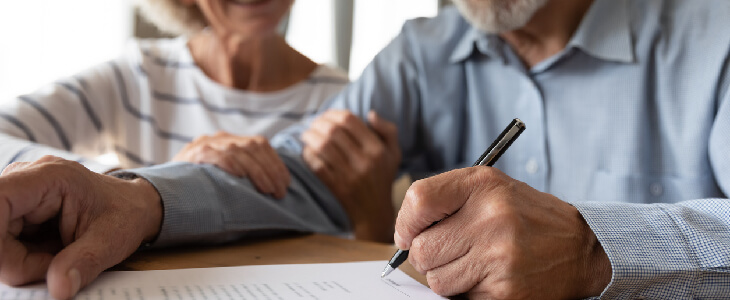 elderly couple signing estate planning legal documents