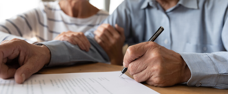 elderly couple signing estate planning documents