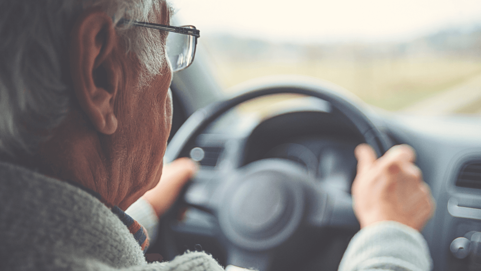 an elderly man driving a car