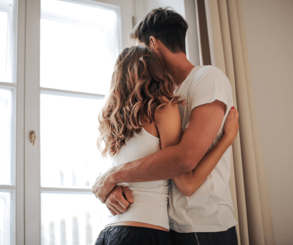 young couple hugging after they created an estate plan by a window