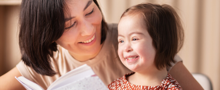 Mom reading book to special needs daughter