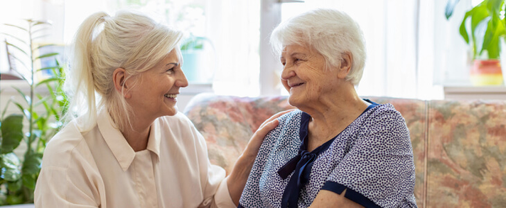Woman smiling with her elderly mother who has dementia