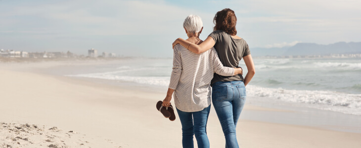 Mother and daughter walking along a beach