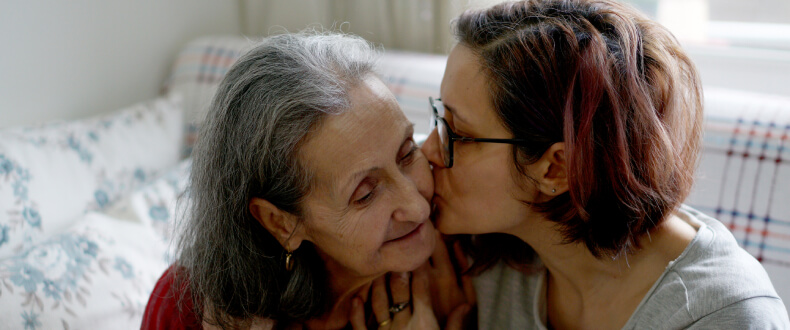 Senior woman embracing caregiver