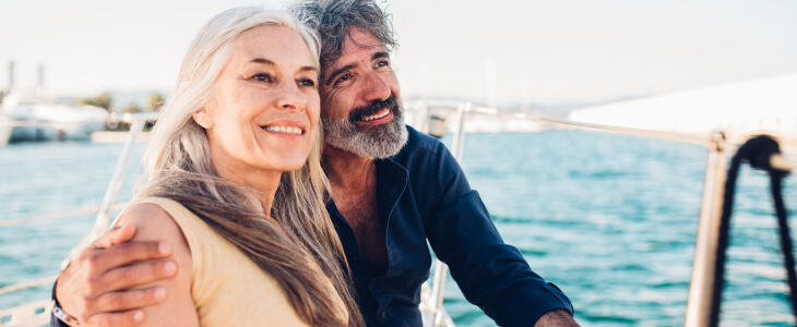 Man and woman smiling on a sailboat