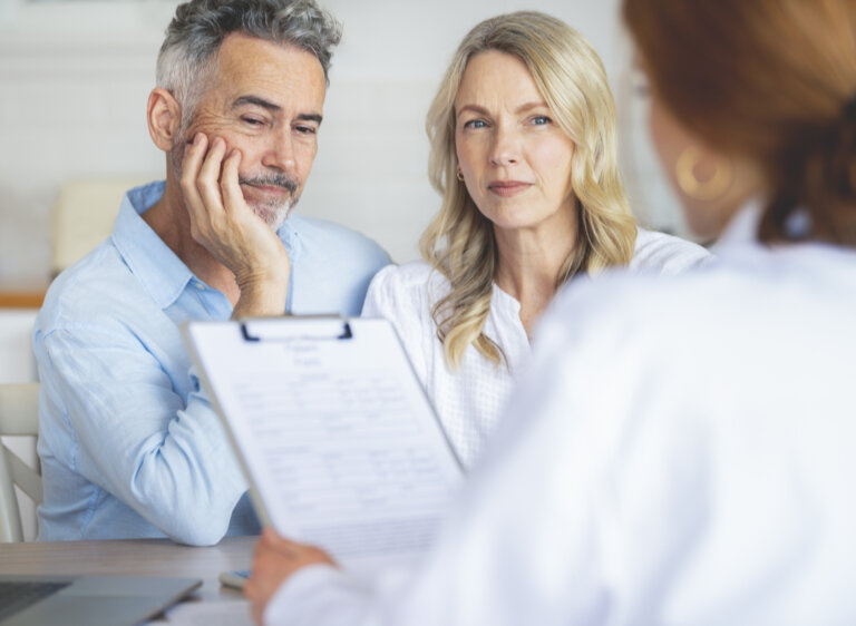 Couple discussing health insurance coverage with doctor