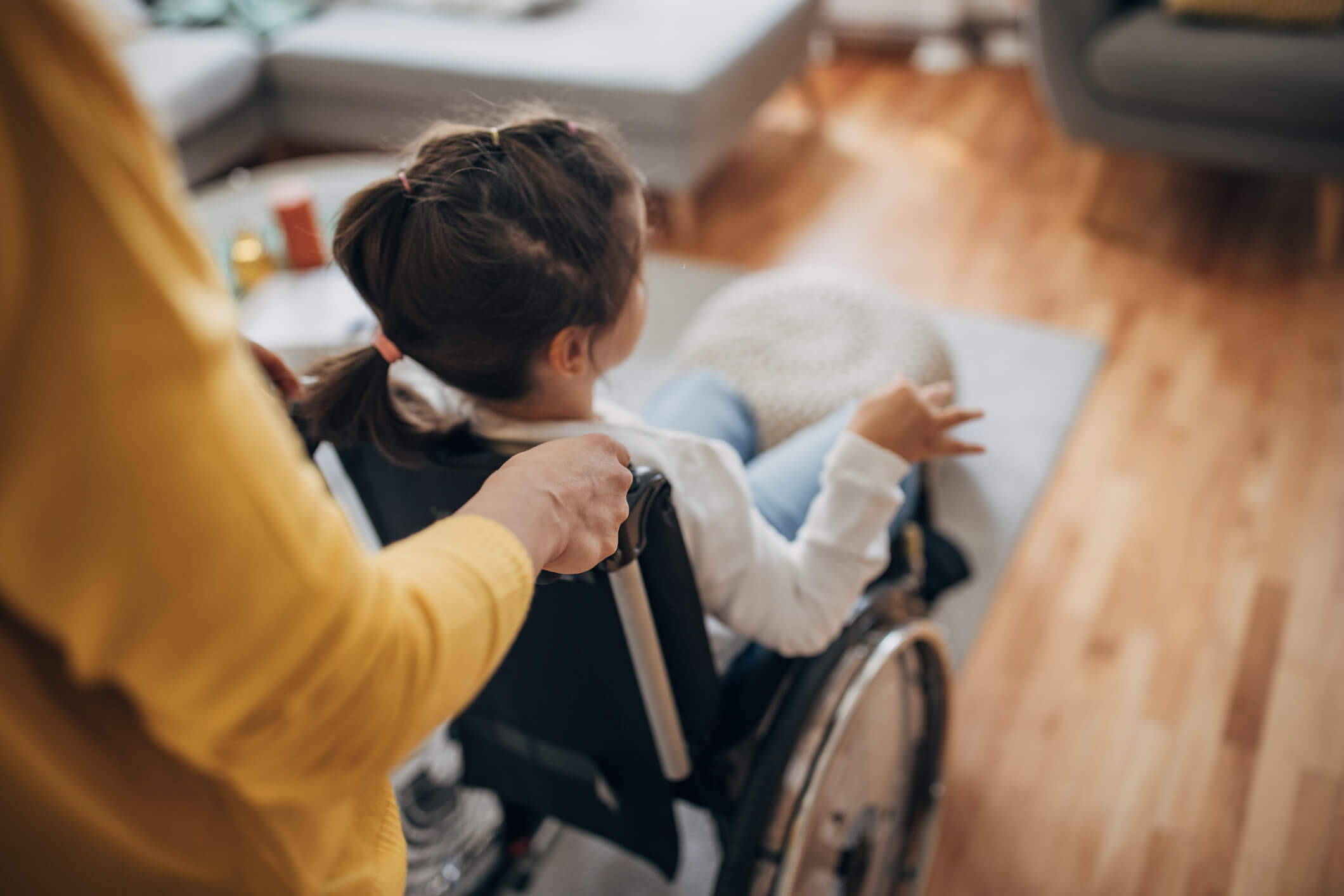 Mother pushing her young daughter who is in wheelchair