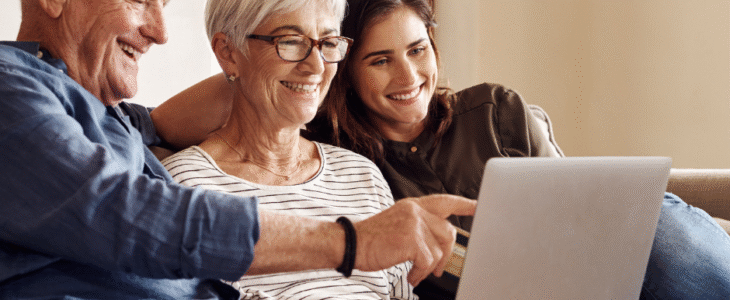 A happy family uses a laptop on a couch. Image from Surprenant, Beneski & Nunes.