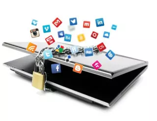 Graphic of laptop tied with a locked metal chain with icons of social media platforms floating around it