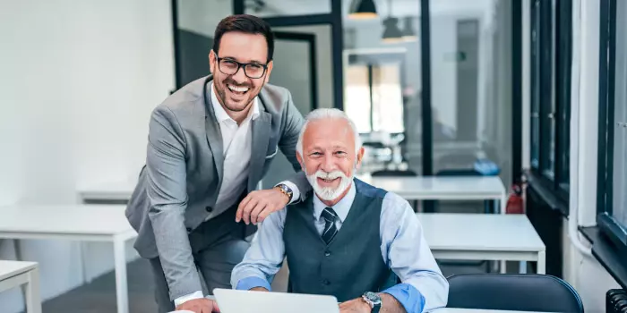 older and younger businessman working in an office