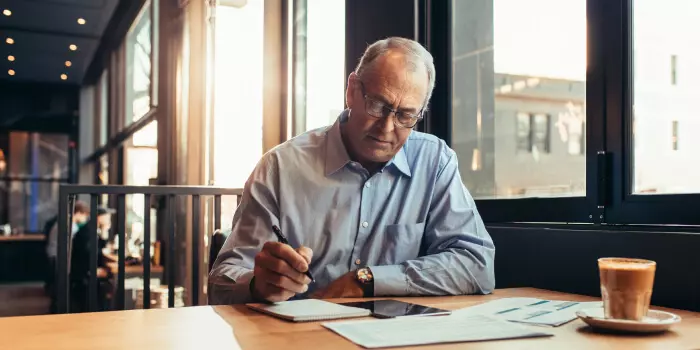 older businessman working in a cafe