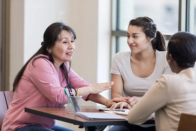 Woman discussing with her banker if she should add her daughter to the account.