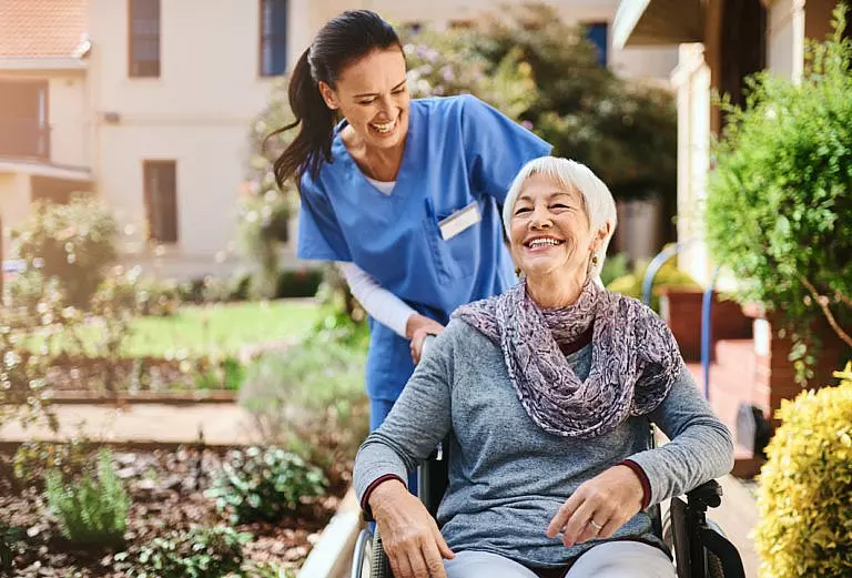Older woman in a nursing home in the care of her nurse.