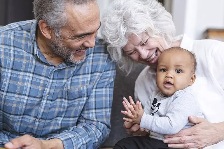 Grandmother and grandfather holding their grandson.