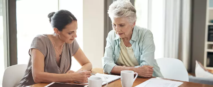 mother and daughter looking down at a notebook asset protection