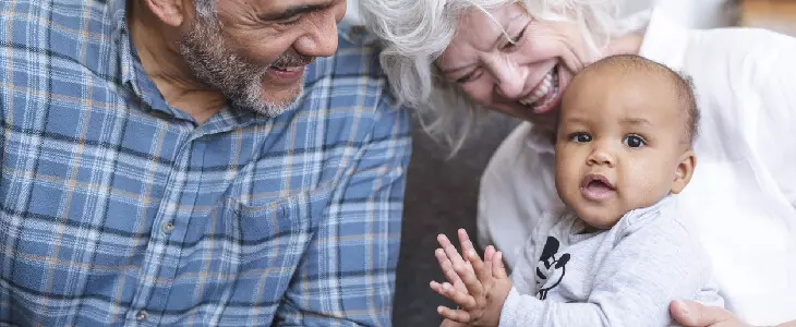 grandparents with their grandchild smiling