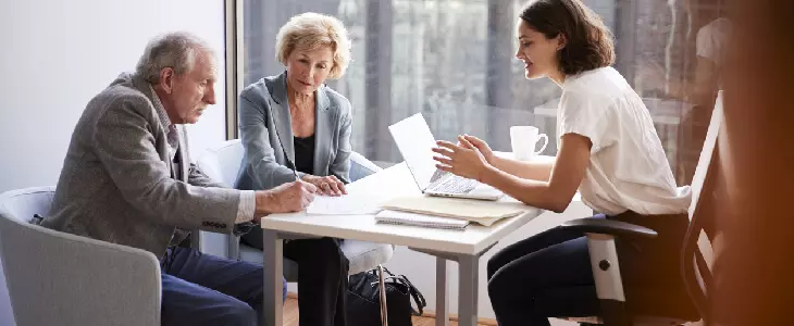 elderly couple speaking with an attorney about their trust