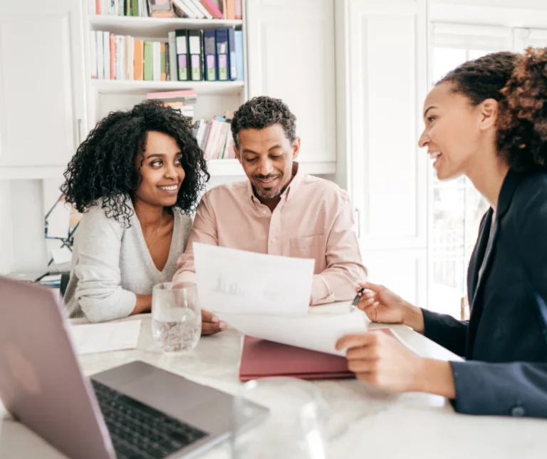 a group of people filling out papers on a desk