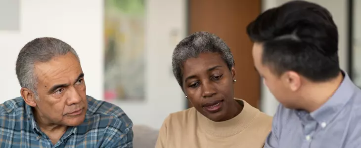 middle-aged couple talking to a lawyer and looking at documents