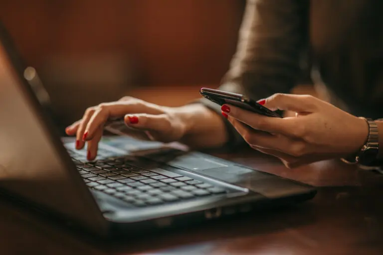 woman on laptop and phone