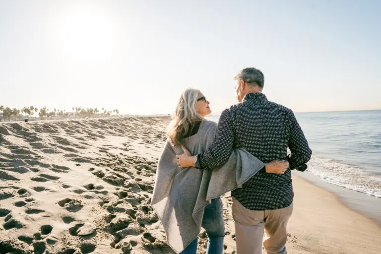 older couple walking on the beach