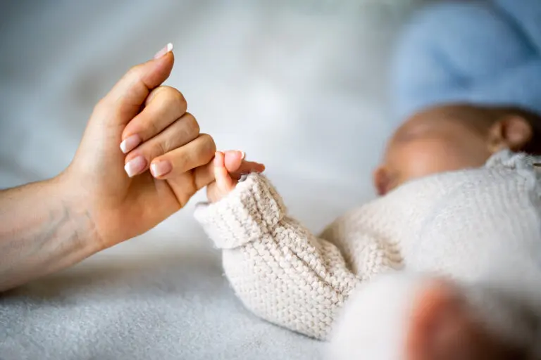 baby holding mom's hand