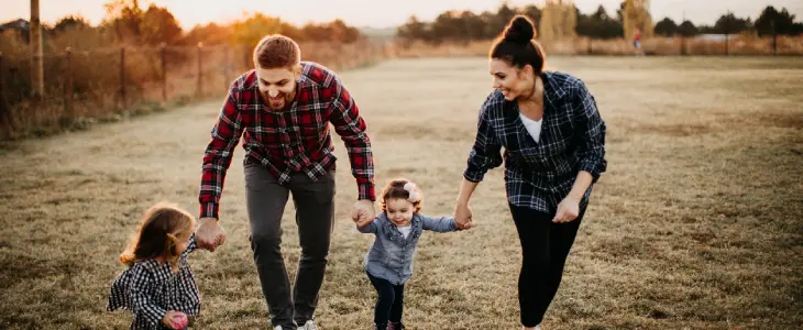 Parents with children playing outside at sunset