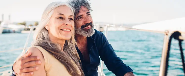 Man and woman smiling on a sailboat