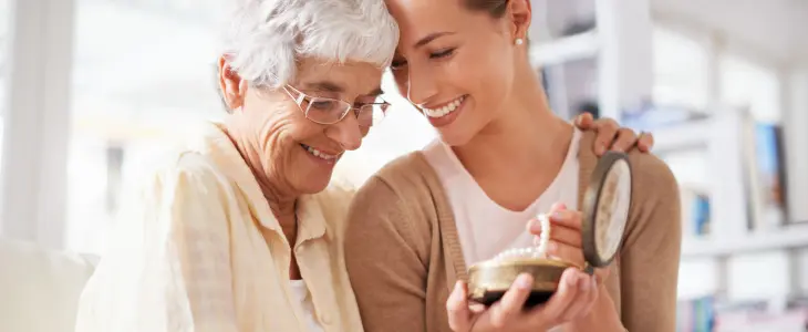 Young woman with grandmother looking at heirloom jewelry