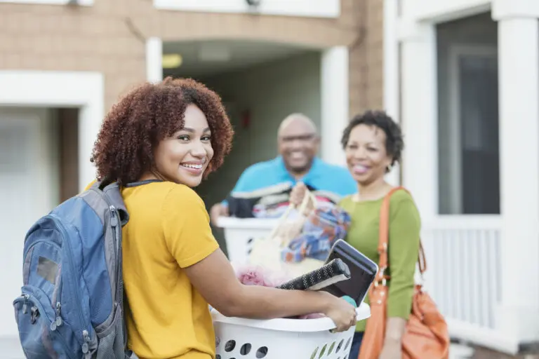 Female college student moving into dorm with help from parents