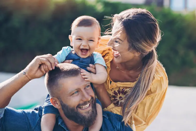 Happy family with a baby walking in the park
