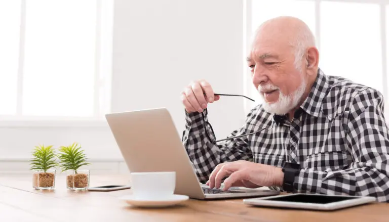 Smiling senior man using laptop