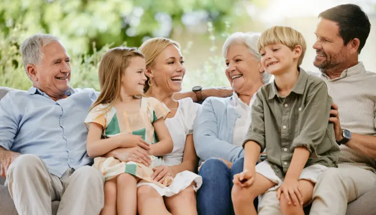 Love, smile and a big family on a sofa in the living room of their home together during a visit. Happy, trust or support with young children, parents and grandparents bonding in an apartment