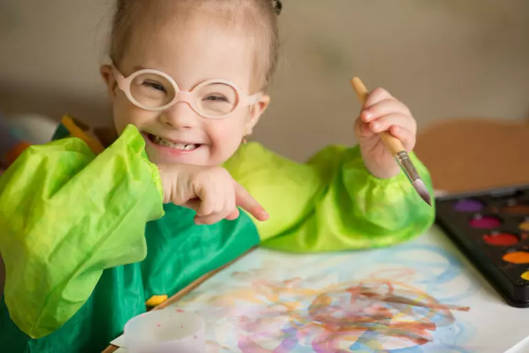 Girl with Down syndrome covered in paint